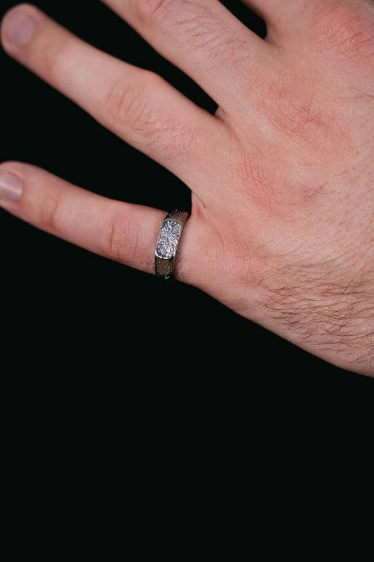 EXCITÀRE Ring silver close-up on hand, showing engraved EXCITÀRE logo and detailed texture against a black t-shirt.