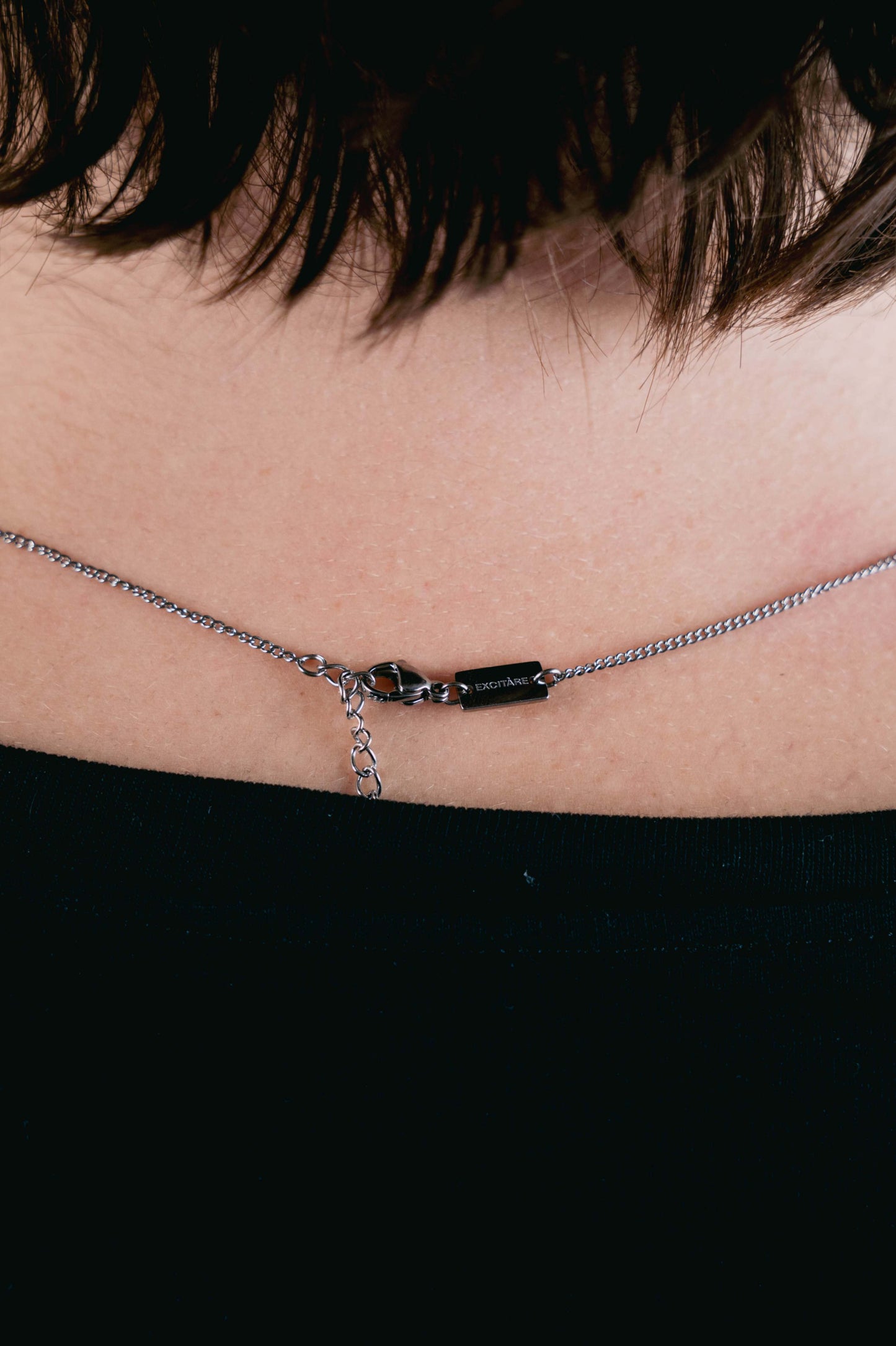 EXCITÀRE necklace clasp in silver with engraved logo and adjustable chain detail.