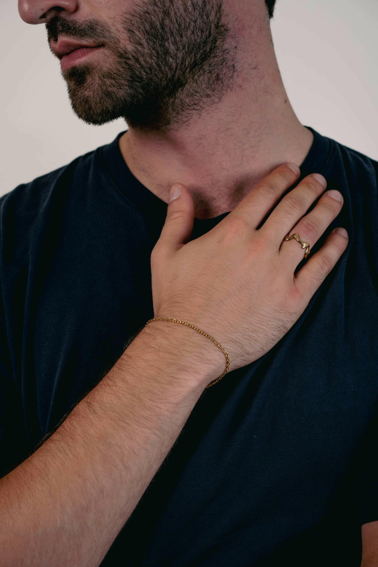 Man wearing the EXCITÀRE Ember Ring gold with the Nova gold bracelet.