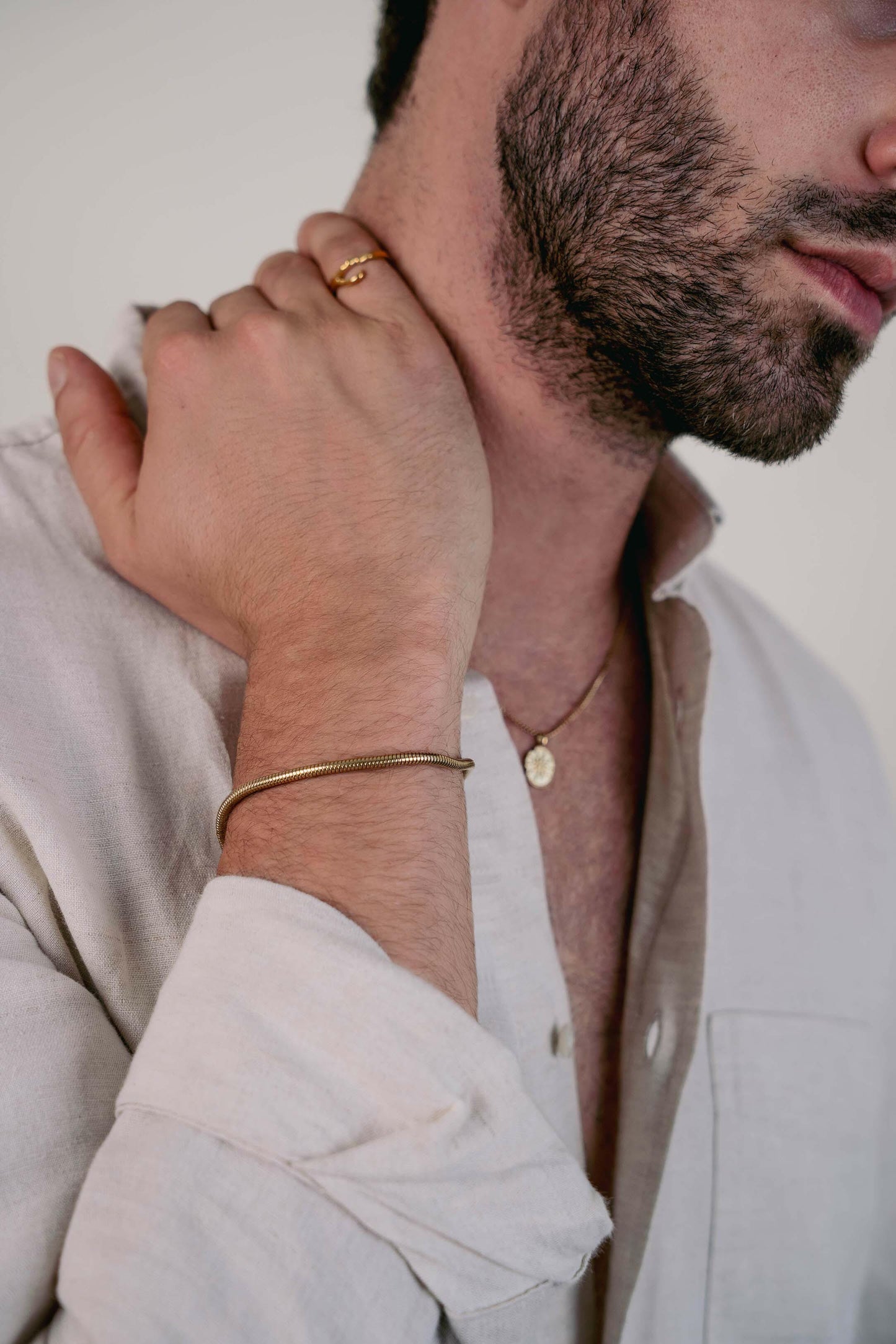 EXCITÀRE Figaro Bracelet gold with sleek rounded links, styled with gold ring and linen shirt.