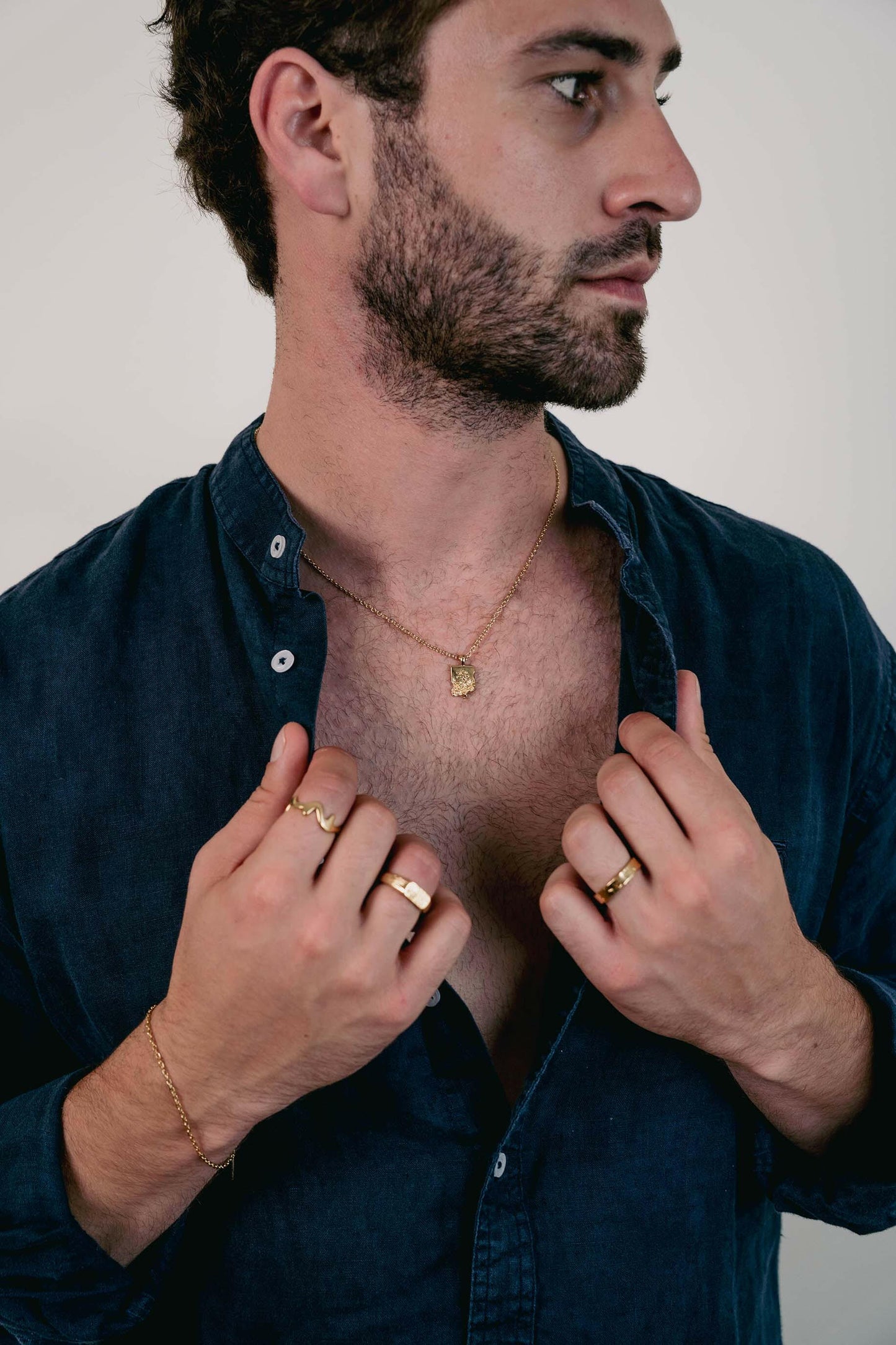 EXCITÀRE Flower Necklace gold with floral pendant, styled with gold rings and bracelet.