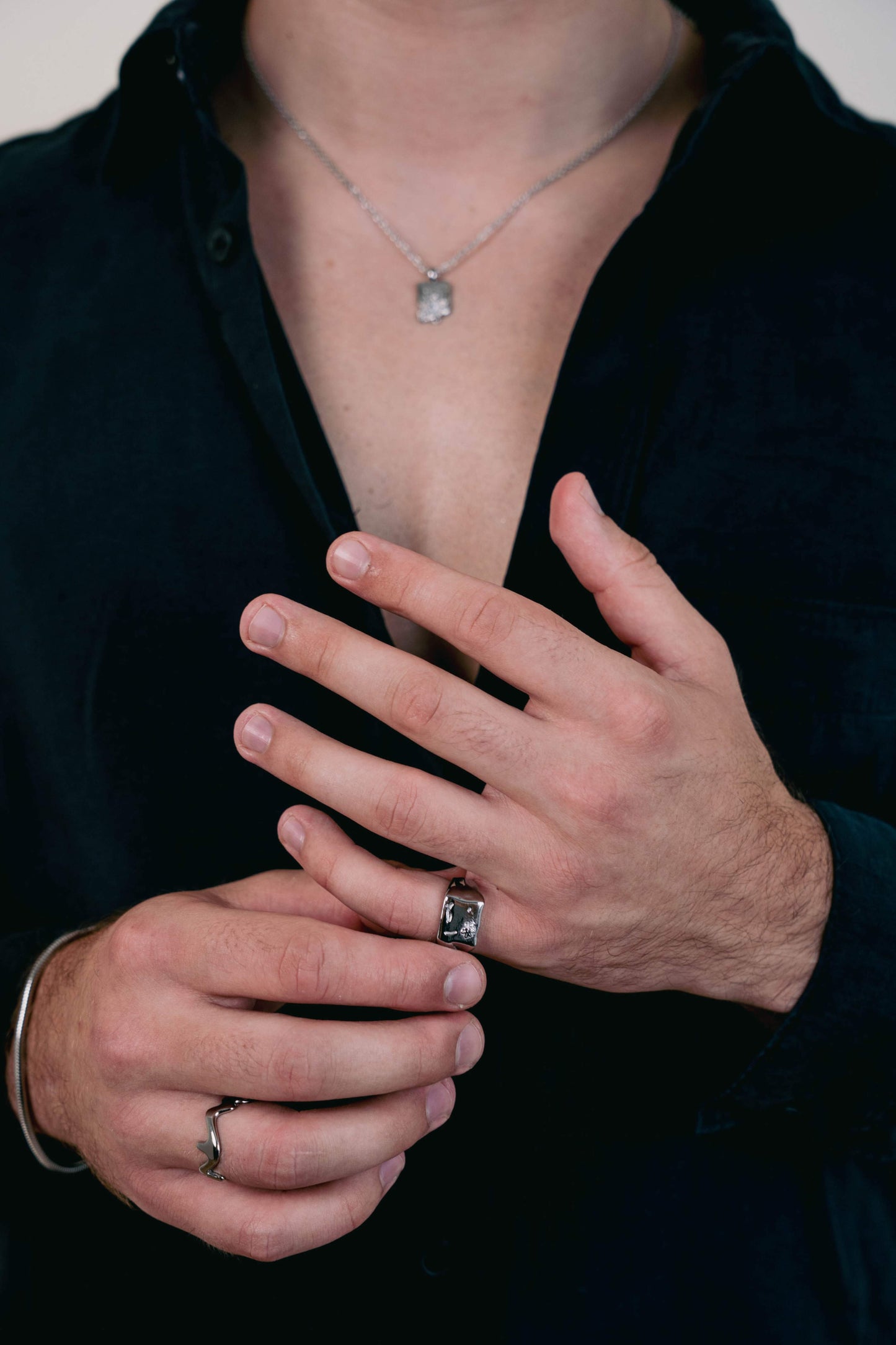 Model wearing the EXCITÀRE Flower Ring silver and EXCITÀRE Wave Ring silver, styled with a black shirt and matching silver necklace.
