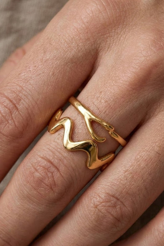 Close-up of the Ember Ring Gold Extra, featuring a smooth wave-shaped minimalist design in gold, worn on the hand.