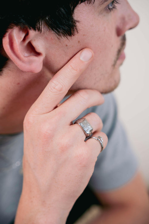 Close-up of a hand wearing a minimal silver ring, clean and understated for everyday outfits.