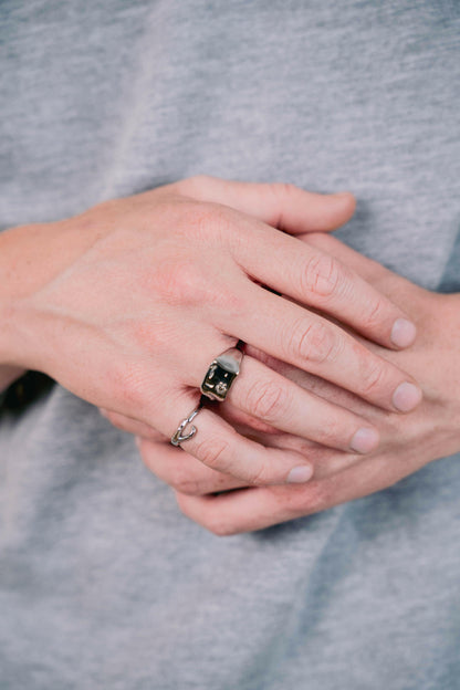 EXCITÀRE Ellis Ring silver and EXCITÀRE Ring silver worn on left hand, fingers interlocked, model in grey shirt.