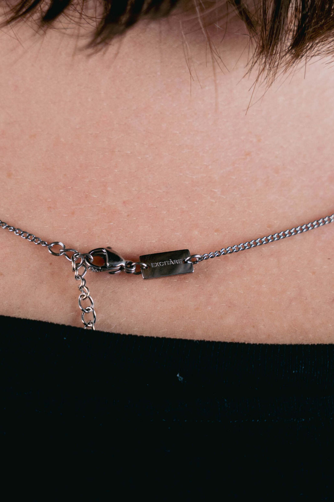 EXCITÀRE necklace clasp in silver with engraved logo and adjustable chain detail.