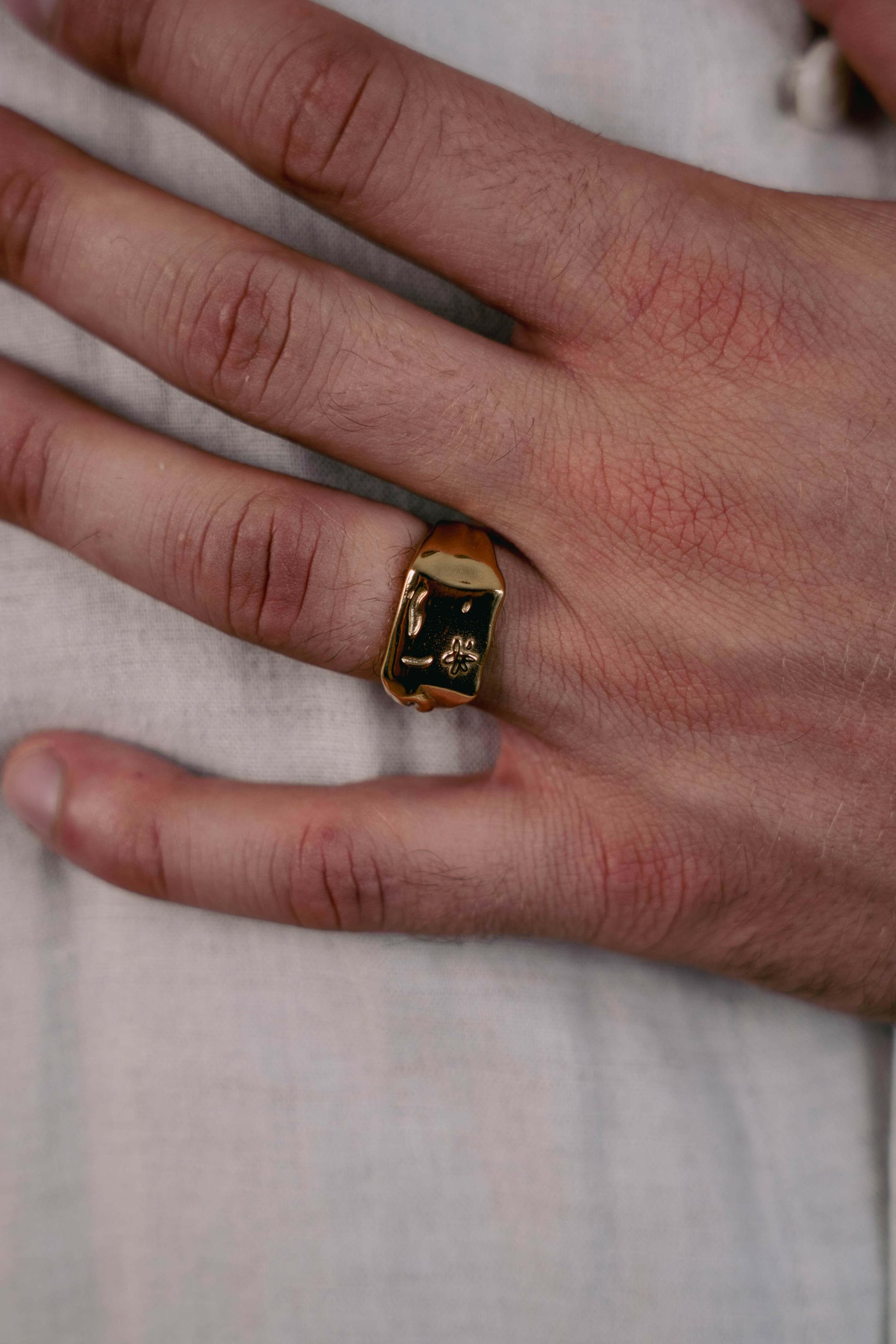 Close-up of the EXCITÀRE Flower Ring gold on finger.
