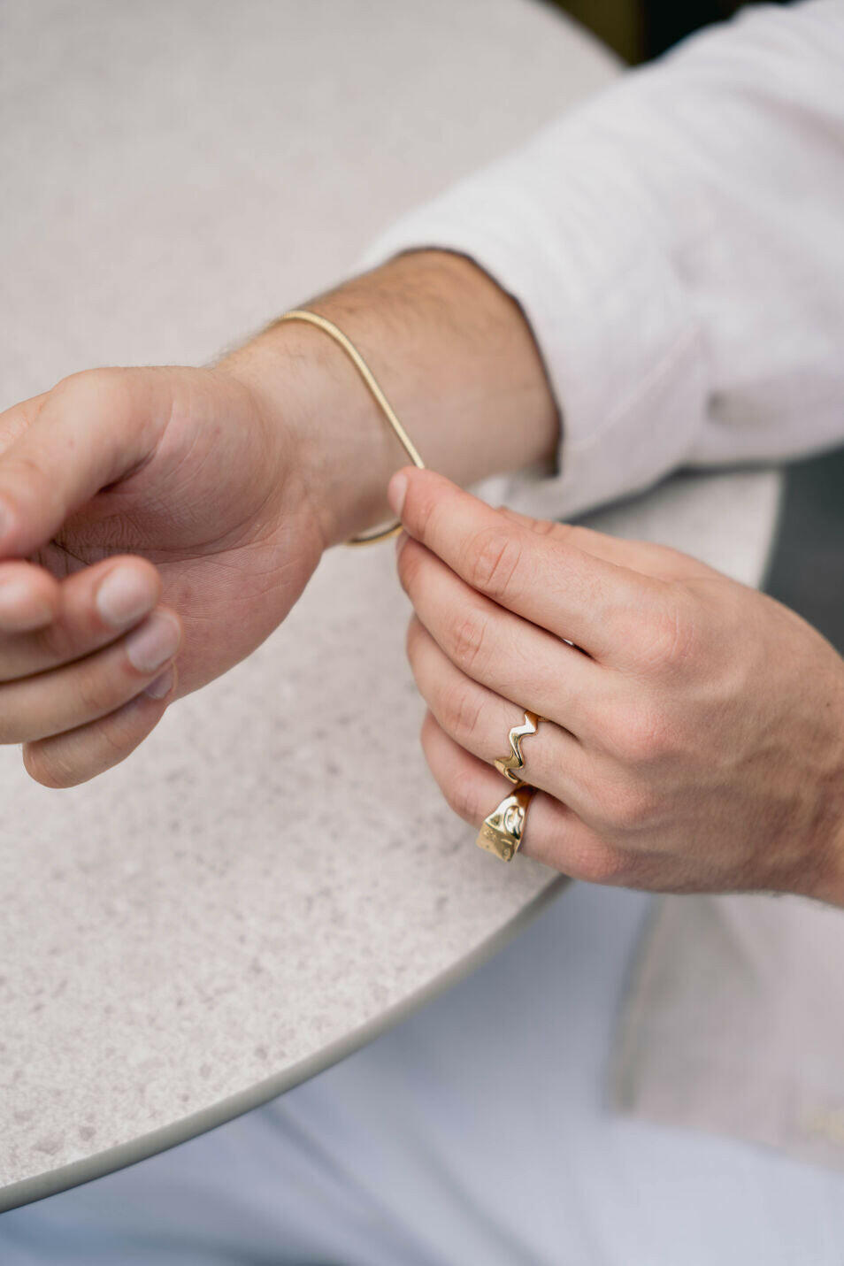 EXCITÀRE Flower Ring gold styled with matching bracelet on a terrazzo tabletop.
