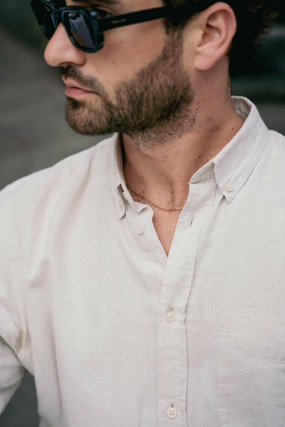EXCITÀRE Nova Necklace gold, gold chain worn around the neck, styled with open cream shirt and head turned sideways.