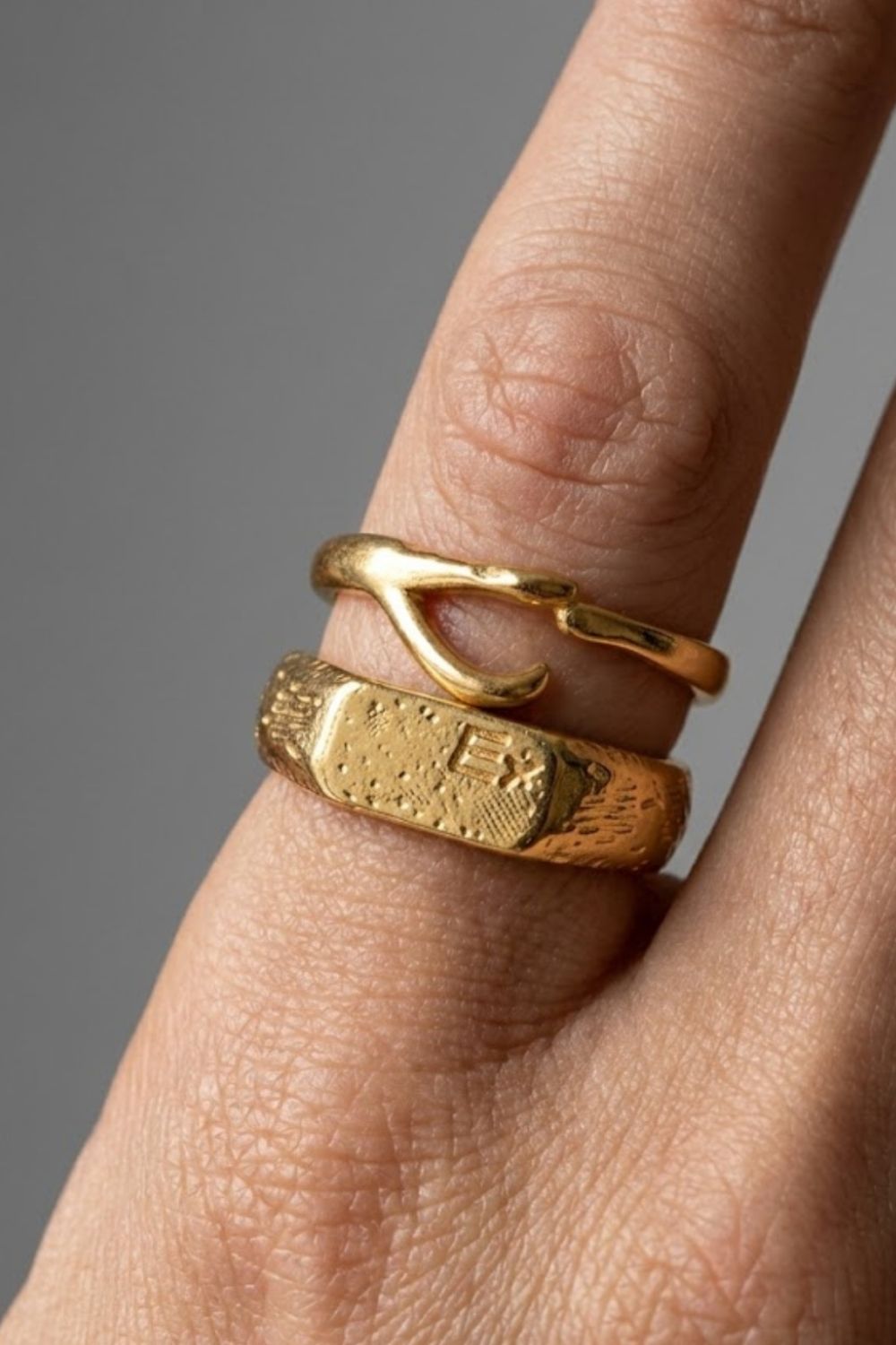 Close-up of the Ellis Ring Gold, showing layered minimalist gold rings including a signet design, worn on the hand.