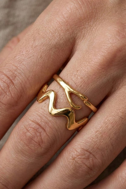 Close-up of the Ember Ring Gold Extra, featuring a smooth wave-shaped minimalist design in gold, worn on the hand.